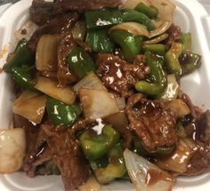 a white plate topped with meat and veggies covered in brown gravy