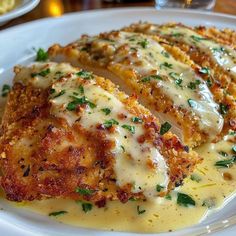 chicken parmesan on a white plate with gravy and garnish