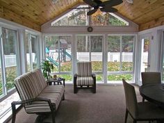 a living room filled with furniture and lots of windows on top of it's walls