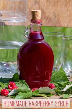 a bottle of raspberry syrup surrounded by glasses