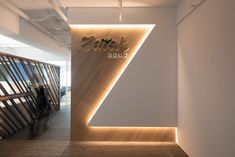 the interior of an office building with wooden walls and lighting on either side of the wall