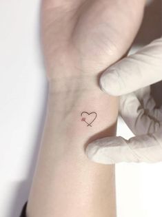 a small heart tattoo on the wrist