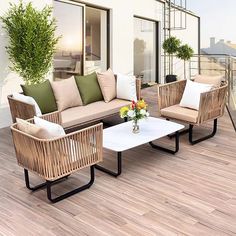 an outdoor living area with wicker furniture and potted plants on the roof terrace