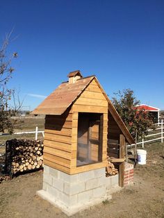 a small wooden building sitting in the middle of a field