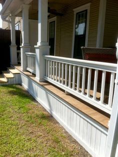 a porch with steps leading up to the front door and side yard area on either side of the house