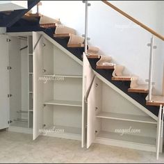 an empty room with some stairs and cabinets in it's center, next to a white closet