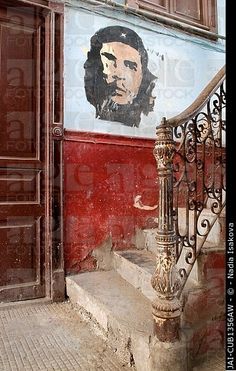 an old building with stairs and paintings on the side wall, in front of a door