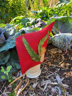 This listing is for a unisex baby gnome or pixie hood. It is made of heathered red Merino wool felt.  It is lined in black linen. It has a pointed top and a cute fern and mushroom design in wool applique on one side - I cut the appliques freehand so no two are quite alike, you will receive the exact one in these photos . There are soft cotton ribbon ties under the chin.  An easy accessory for a costume or just for fun! Will fit babies 6-12 months old. Hand wash, dry flat. Pixie Hat Pattern, Coos Bay, Pixie Hat, Cotton Ribbon, Mushroom Design, Wool Applique, Black Linen, Unisex Baby, Hat Pattern