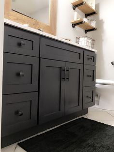 a bathroom with black cabinets and a white toilet