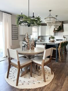 a dining room table surrounded by chairs with christmas decorations on the top and around it