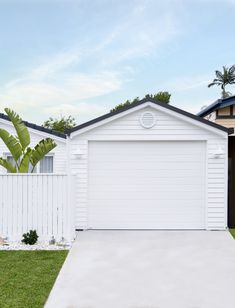 a white house with a palm tree in the front yard