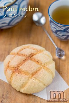 a close up of a pastry on a table with a cup of tea in the background