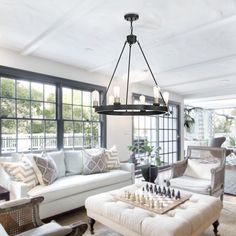 a living room filled with furniture and a chess board on top of a coffee table