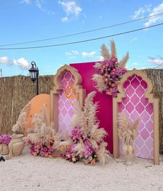 a pink and gold decorated stage set up for an outdoor event with flowers on it