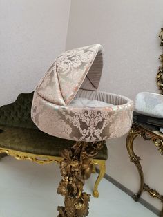 a baby carriage sitting on top of a table next to a mirror and gold furniture