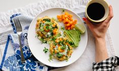 a plate with eggs, avocado and carrots next to a cup of coffee