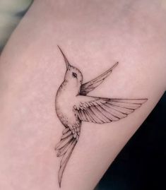 a small hummingbird tattoo on the right side of the leg, it is black and white