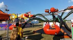 an amusement park ride with people riding on the rides and in the background are carnival rides