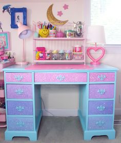 a pink and blue desk with lots of stuff on it's shelves in a room