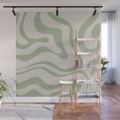 a room with a book shelf, plant and wallpaper on the walls that has an abstract pattern