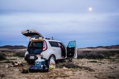 the car is parked in the desert with its trunk open