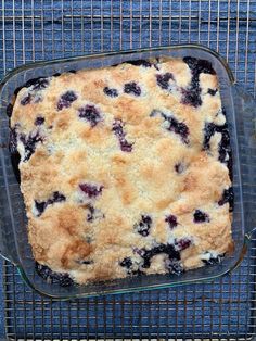 a blueberry cobbler in a glass baking dish on a cooling rack, ready to be eaten