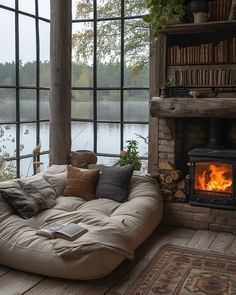 a couch sitting in front of a fire place next to a window filled with books