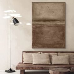 a living room scene with focus on the couch and large painting hanging over the wall