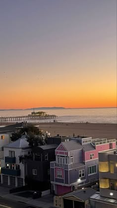 the sun is setting over some colorful houses on the beach in san francisco, california