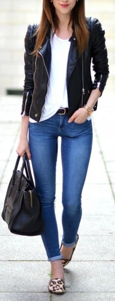 a young woman is walking down the street with her hand in her pocket and holding a purse