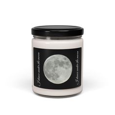 a white candle with a black lid and the moon on it