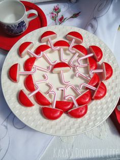 there is a plate that has some red hearts on it and white sticks sticking out of the cake