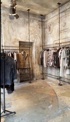 an old fashion clothing store with clothes hanging on racks and other items in the room