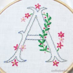 a floral monogram with the letter a in it's center is embroidered onto a white cloth