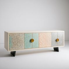 the sideboard is painted with different colors and designs, including dots on the doors