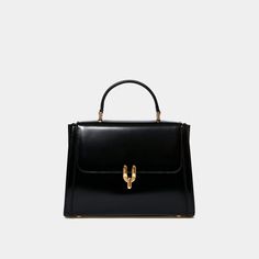 Dimensions : 23x17x6cm / 9x6.6x2.3inch50's inspired glossy calfskin bag with brass Diapason clasp. Created in collaboration with Laurence Fortin-Côté, this bag is inspired by her chic and vintage style. Can be carried by hand or on the shoulder with its adjustable leather shoulder strap. Made in Italy. Asymmetrical Bag, Elegant Watches Women, Classy Purses, Iphone Pro, Classic Handbags, Classic Bags, Travel Wardrobe, Mini Handbags, Stylish Bag