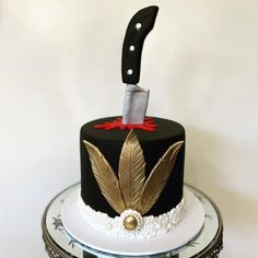 a black and white cake with a knife on top