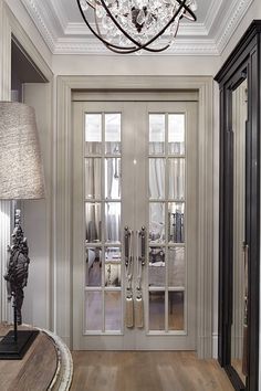 an elegant entry way with glass doors and chandelier