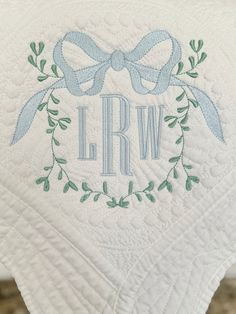 the monogrammed towel has a bow on it and is embroidered with blue ribbon