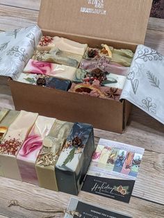 an open box filled with different types of soaps on top of a wooden table