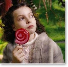 a woman holding a red lollipop in her hand