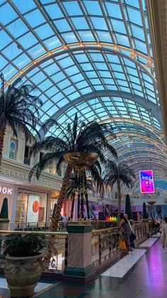 the inside of a shopping mall with palm trees