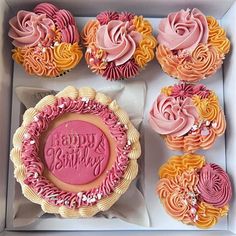 a box filled with cupcakes covered in pink and yellow frosting next to each other