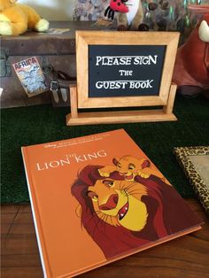 the lion king sign is next to an open book and stuffed animals are in the background