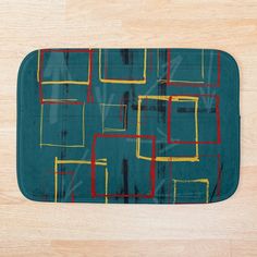 a bath mat with various colored squares on it and a wooden floor in the background