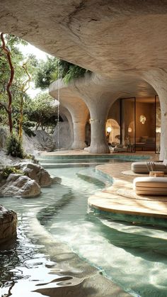 an indoor swimming pool in the middle of a room with large rocks and water features