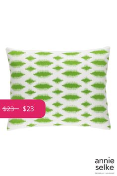 a green and white pillow with the price tag $ 23, which is printed on it