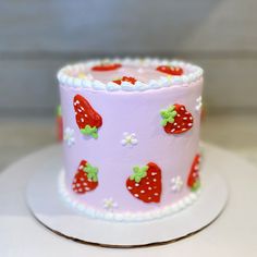 a pink cake decorated with strawberries and flowers