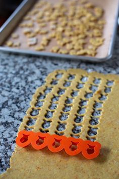 an orange object sitting on top of a counter next to a cookie sheet with holes in it