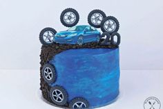 a blue cake decorated with wheels and tires